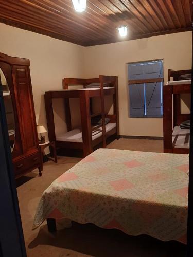 a bedroom with two bunk beds and a window at Casas da Mantiqueira in Bueno Brandão