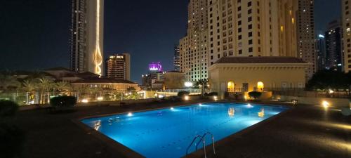 una gran piscina en una ciudad por la noche en Ocean view 8min from the beach Dubai Marina JBR " My Home " en Dubái