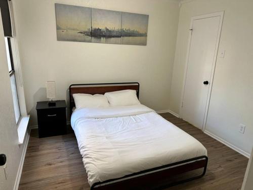 a bedroom with a bed and a painting on the wall at Newly Updated Cozy Home in Garland
