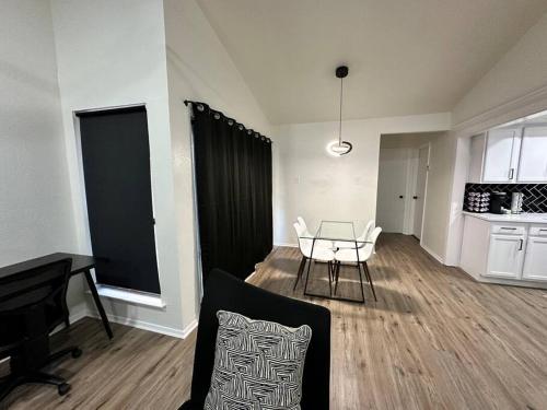 a living room with a table and a kitchen at Newly Updated Cozy Home in Garland