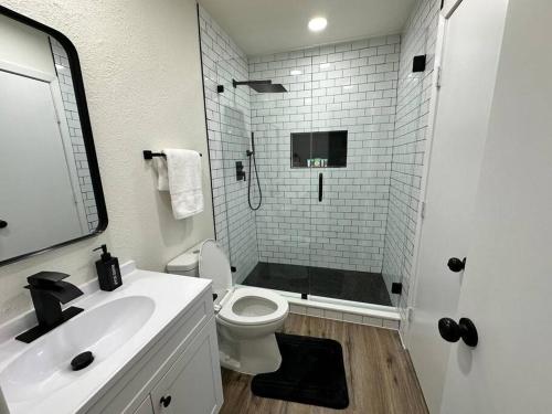 a bathroom with a shower and a toilet and a sink at Newly Updated Cozy Home in Garland