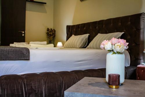 a bedroom with a bed and a vase of flowers on a table at R34 Boutique Guest House in Veliko Tŭrnovo