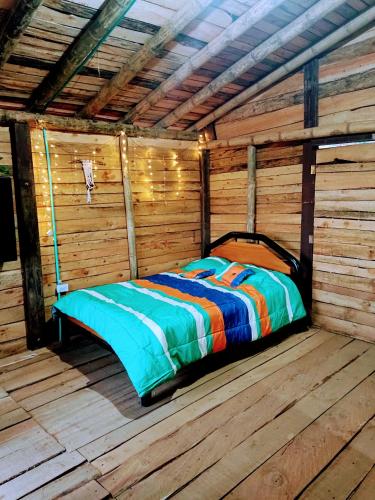 - un lit installé à l'intérieur d'une cabane en bois dans l'établissement Lindo mirador del oriente Antioqueño, à Guarne