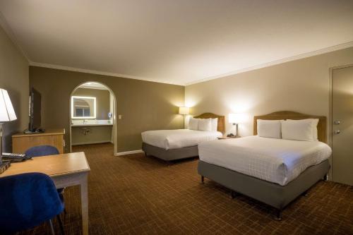 a hotel room with two beds and a desk at Best Western Inn in Redwood City