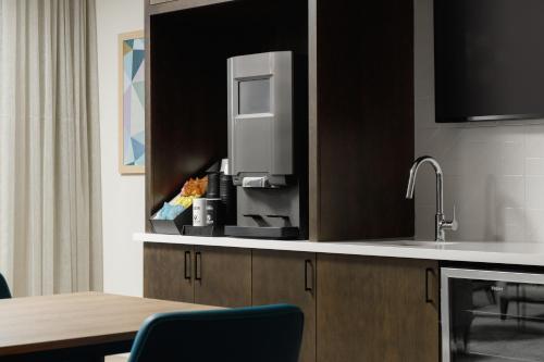 a kitchen with a counter with a refrigerator and a table at WaterWalk Extended Stay by Wyndham Huntsville in Huntsville