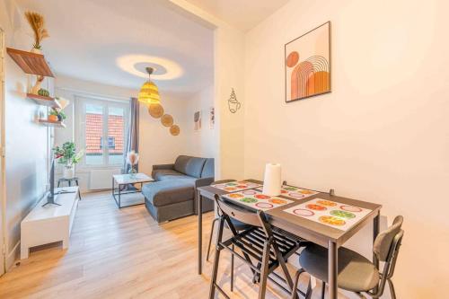 a dining room and living room with a table and chairs at Le Petit Tremblay at 10 min Parc des Expos / CDG in Tremblay En France