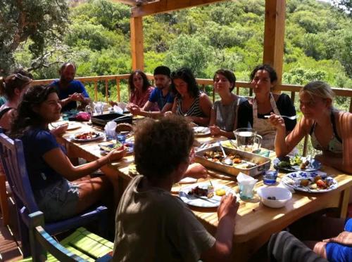 Un grupo de personas sentadas en una mesa comiendo comida en LODGE bennouri, en Telouet