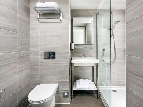 a bathroom with a toilet sink and a shower at Mercure Newport in Newport
