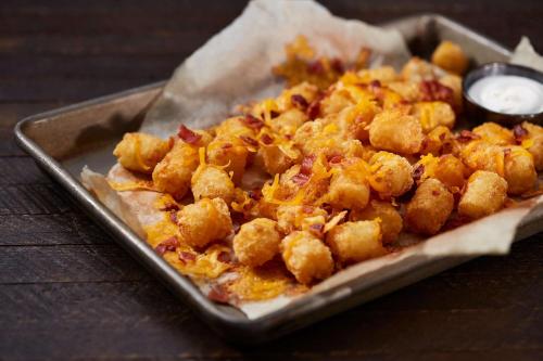 a tray of food with tater tots on a table at Drury Plaza Hotel Nashville Downtown in Nashville