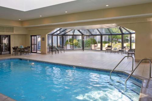 a pool in a hotel with tables and chairs at Sonesta Select Minneapolis Eden Prairie in Eden Prairie