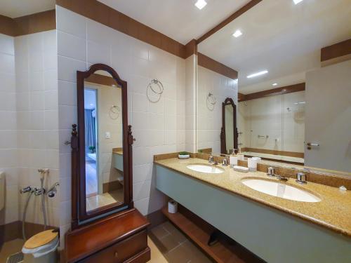 a bathroom with two sinks and a large mirror at Duplex Cobertura - Gramado Wish Serrano in Gramado