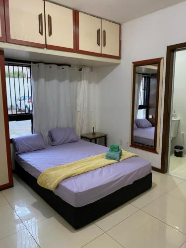 1 dormitorio con 1 cama grande y espejo en Lindo Flat pé na areia, en Salvador