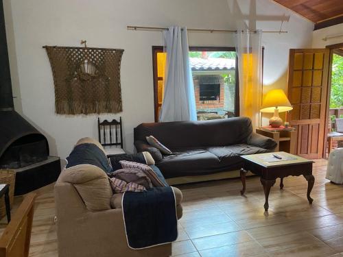 Ruang duduk di Lumiar linda vista das montanhas, com lareira, churrasqueira, wifi, Tv a cabo, casa ampla, arejada jardim pertinho do centro de Lumiar e de cachoeiras