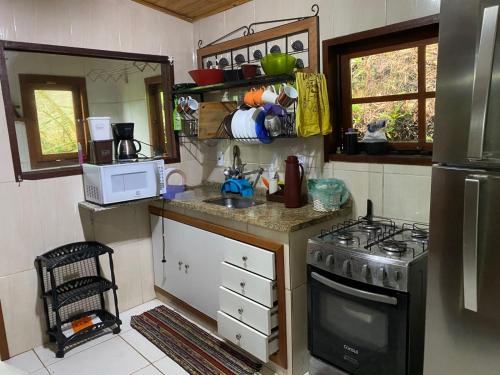 Dapur atau dapur kecil di Lumiar linda vista das montanhas, com lareira, churrasqueira, wifi, Tv a cabo, casa ampla, arejada jardim pertinho do centro de Lumiar e de cachoeiras