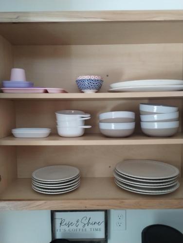 a shelf filled with plates and bowls and dishes at Beargrass Lodging & RV Resort in Hungry Horse