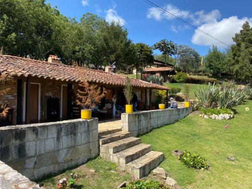 a house with a stone wall and a yard at Mitanni in Santa Isabel