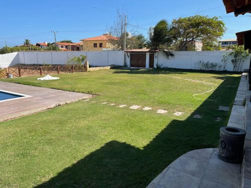 a yard with a fence and a large yard withgrass at Casa de Praia - Prainha in Aquiraz