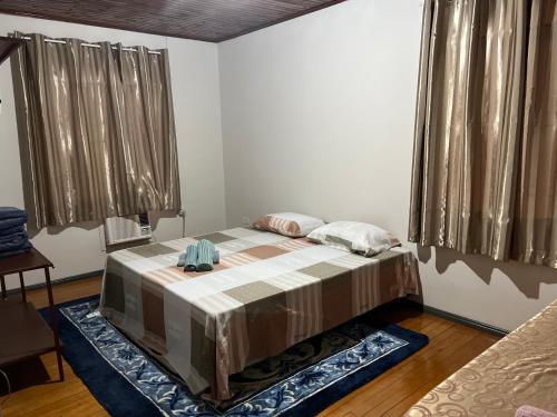 ein Schlafzimmer mit einem Bett in einem Zimmer mit Fenstern in der Unterkunft Casa na Vila Yolanda in Foz do Iguaçu