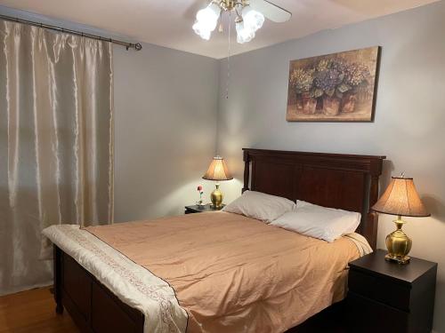 a bedroom with a bed with two lamps and a painting at Bright room in a castle in Markham