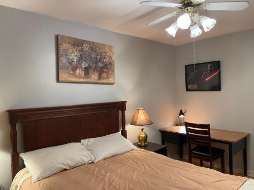 a bedroom with a bed and a desk and a ceiling fan at Bright room in a castle in Markham