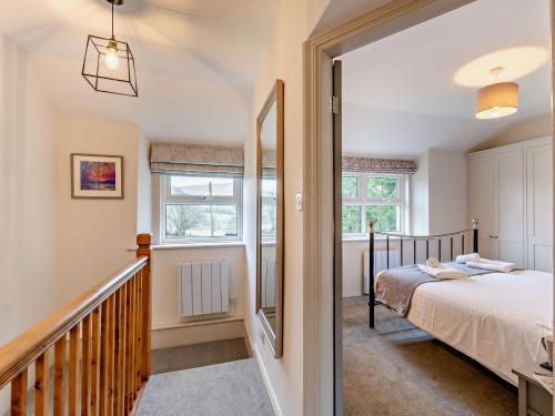 a bedroom with a bed and a staircase with a mirror at 2 Bed in Keswick 90064 in Threlkeld