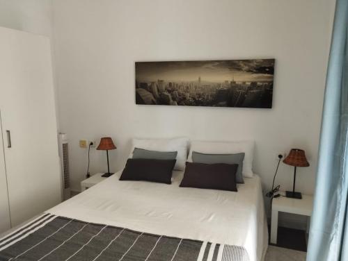 1 dormitorio con 1 cama blanca y 2 lámparas en Apartamentos Marco Sancho Centro-Alameda-Setas en Sevilla