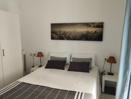 ein Schlafzimmer mit einem weißen Bett mit zwei Lampen in der Unterkunft Apartamentos Marco Sancho Centro-Alameda-Setas in Sevilla