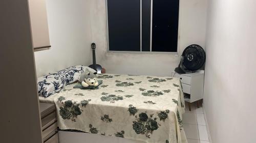 a child laying on a bed with a teddy bear on it at Apartamento tupã in Propriá