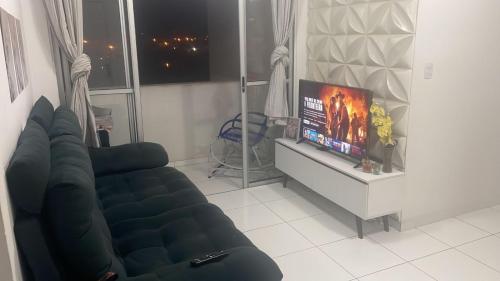 a living room with a couch and a flat screen tv at Apartamento tupã in Propriá