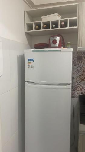 a refrigerator in a kitchen with a toaster on top of it at Apartamento tupã in Propriá