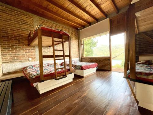 Ce lit se trouve dans un dortoir doté de 2 lits superposés et d'un mur en briques. dans l'établissement Gran CASA FINCA embalse de Tominé wi-fi, tv, BBQ, à Sesquilé