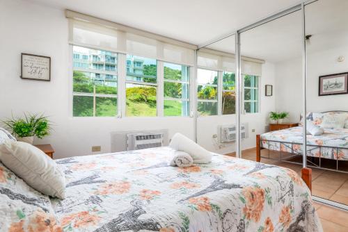 a bedroom with two beds and two windows at Tropical Villa Ocean View in Maunabo
