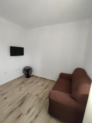 Pousada Provinelli في باليوسا: غرفة معيشة مع أريكة وتلفزيون بشاشة مسطحة