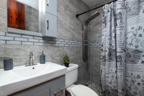 a bathroom with a sink and a toilet and a shower curtain at Tropical Villa Ocean View in Maunabo