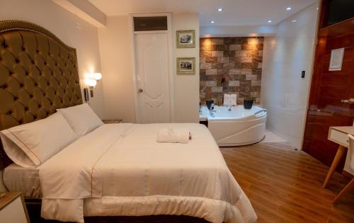 1 dormitorio con cama, bañera y lavamanos en Hotel Melthon Urbans, en Ayacucho
