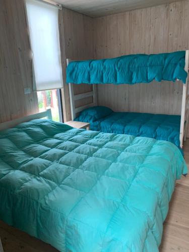 1 cama con edredón azul en una habitación en Casa2 Isla Negra, en Isla Negra