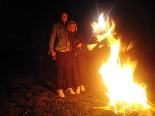 two people standing next to a bonfire at night at Hospedaje Villa Rosita Suesca in Suesca