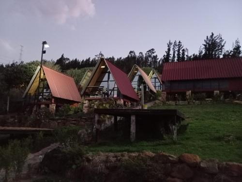a group of houses with red roofs in a field at Hospedaje Villa Rosita Suesca in Suesca