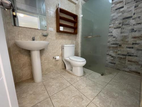 a bathroom with a toilet and a sink and a shower at Villa Marbella by Potenza Rentals in Santo Domingo