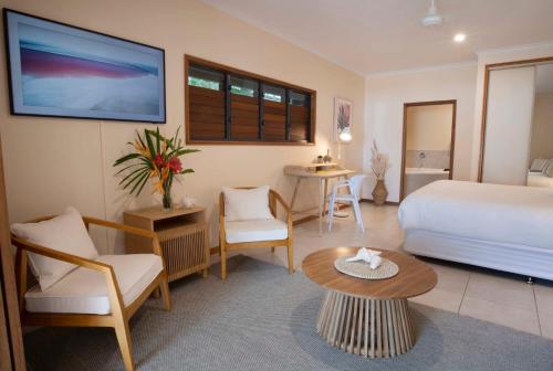 um quarto de hotel com uma cama, uma mesa e cadeiras em Latitude 17 - Suite 1 em South Mission Beach