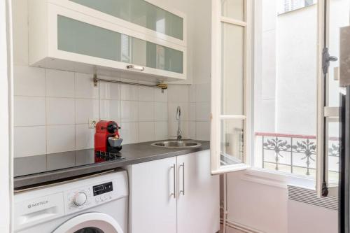 eine Küche mit einer Waschmaschine und einem Waschbecken in der Unterkunft BOULOGNE-PORTE D'AUTEUIL ROLAND GARROS TOURISME in Boulogne-Billancourt