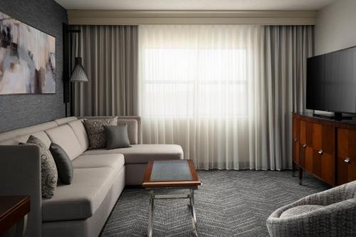 a living room with a couch and a flat screen tv at Minneapolis Marriott Hotel & Conference Center in Brooklyn Park