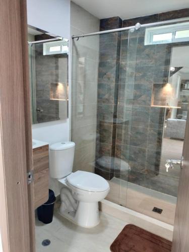 ein Badezimmer mit Toilette und Glasdusche in der Unterkunft JOMAWA Vivienda Turística in Guayabal