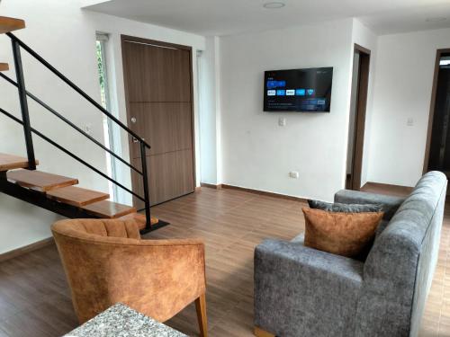 a living room with a couch and a tv on the wall at JOMAWA Vivienda Turística in Guayabal