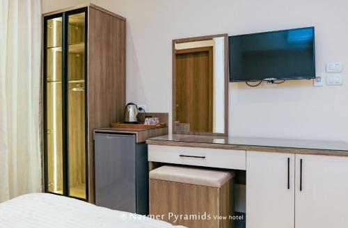 a bedroom with a desk with a television on it at Narmer Pyramids View in Cairo