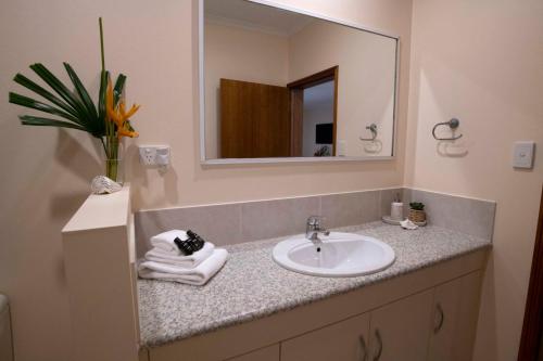 uma casa de banho com um lavatório e um espelho em Latitude 17 - Suite 2 em South Mission Beach