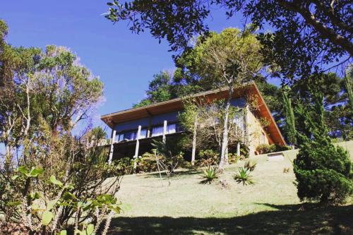 une maison au sommet d'une colline avec des arbres dans l'établissement Refúgio na montanha, à São Francisco Xavier
