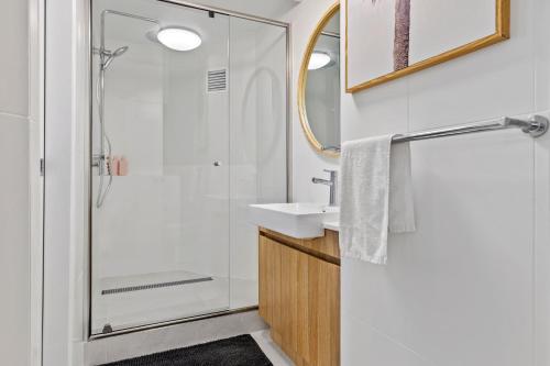 a bathroom with a shower and a sink and a mirror at 2 Bedroom Central Mooloolaba Resort with Pool, Spa, Mini Golf in Mooloolaba