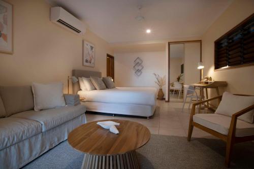 een woonkamer met een bed, een bank en een tafel bij Latitude 17 - Suite 3 in South Mission Beach