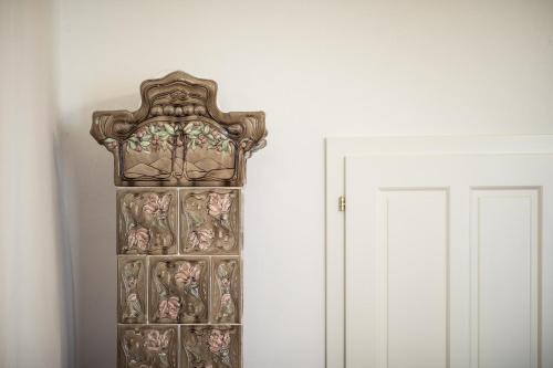 a wooden cabinet with paintings on it next to a door at Romantik Hotel Jagdhof in Caldaro